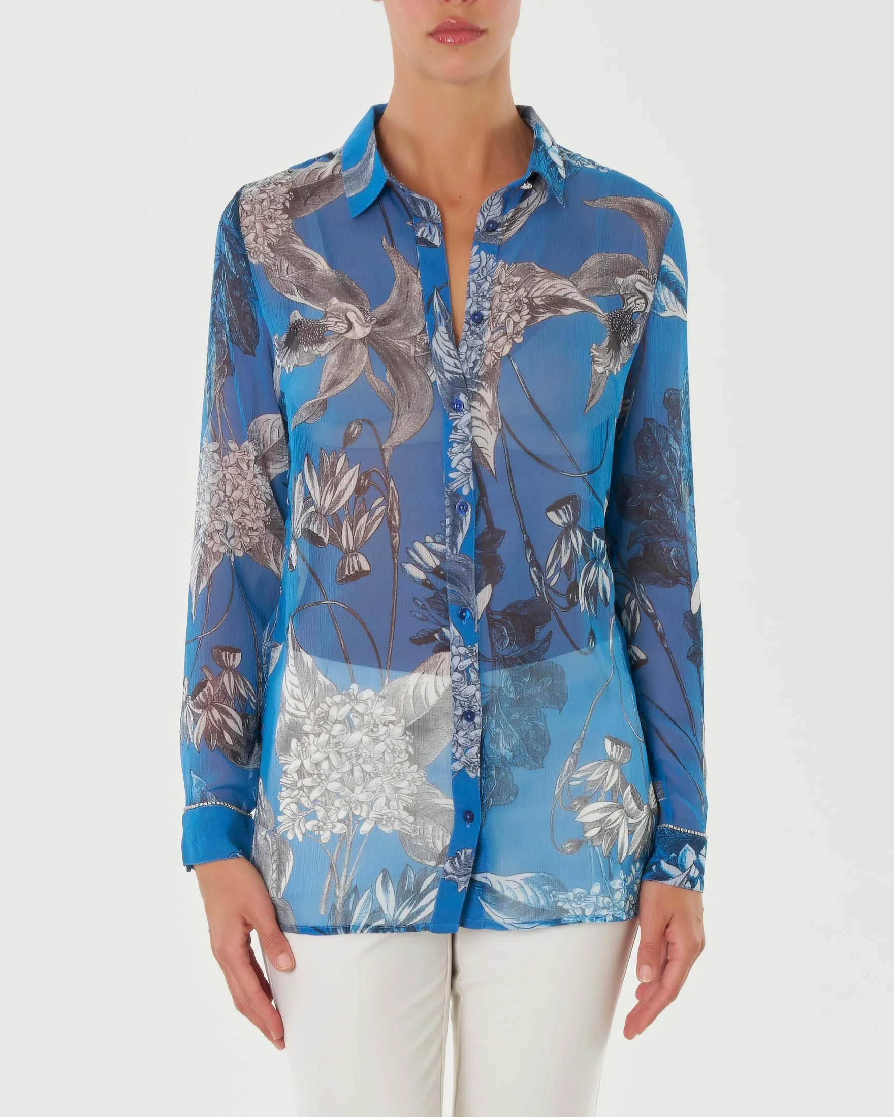 Camicia celeste in creponnene a stampa orchidee grigie con dettaglio in strass lungo il polsino