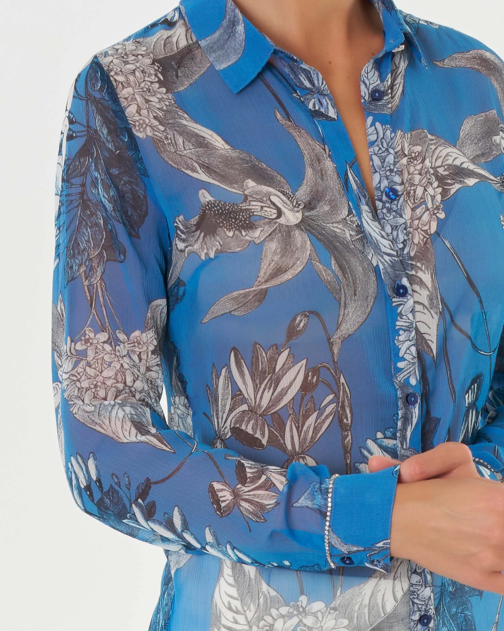 Camicia celeste in creponnene a stampa orchidee grigie con dettaglio in strass lungo il polsino